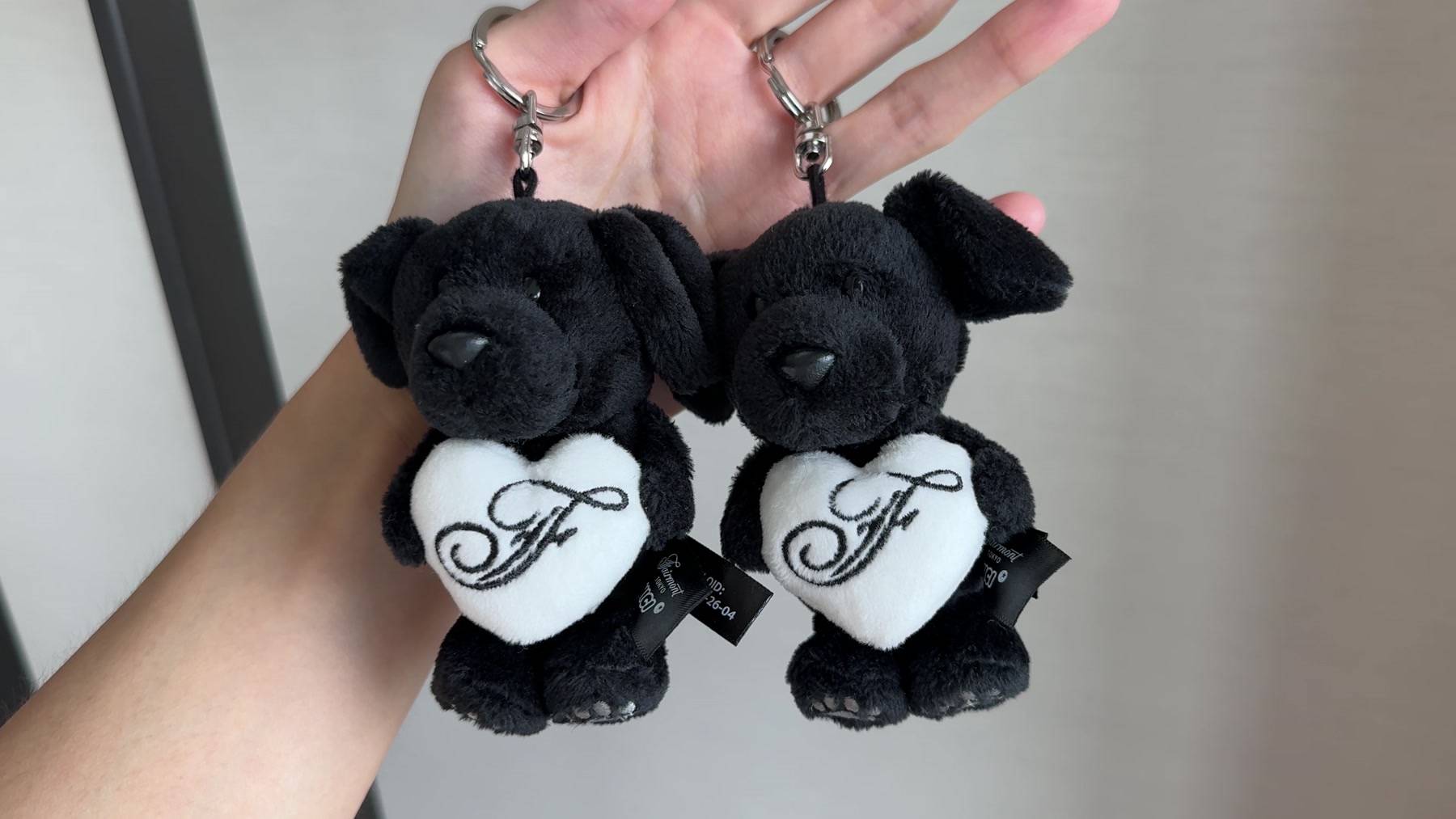Two small Serene Labrador souvenir keyrings with Fairmont monograms