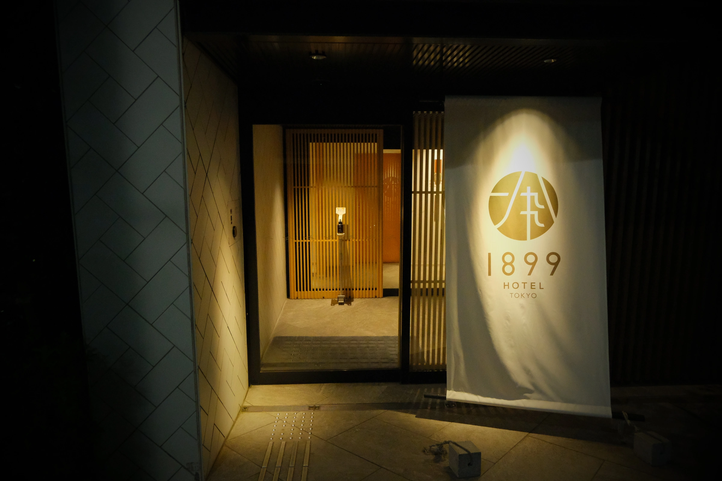 Hotel entrance with wooden screens and the illuminated 1899 curtain