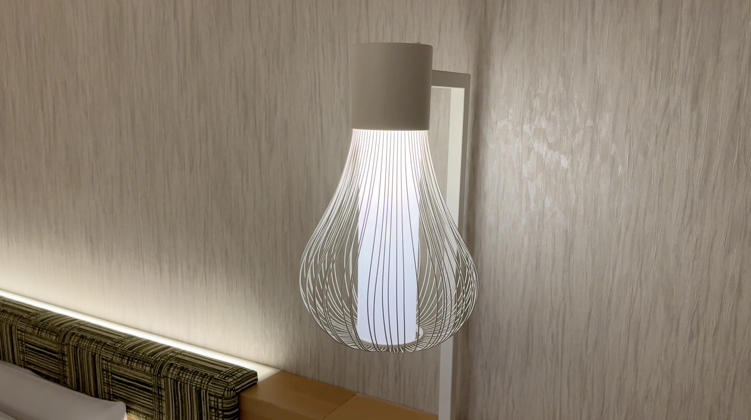 A sculptural bedside lamp beside the green headboard at Hotel 1899 Tokyo