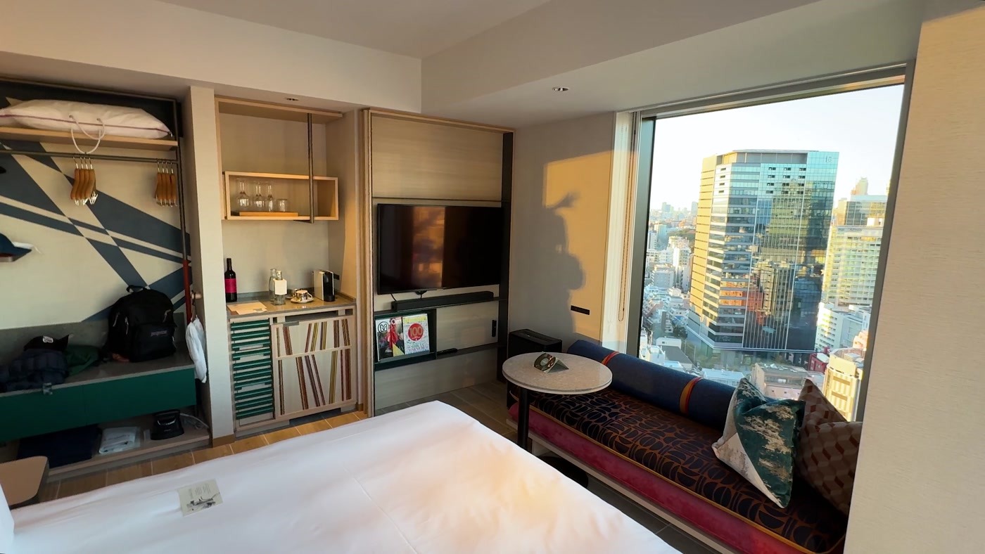 Our king room from the window side, with colorful seating, shelving and Shibuya outside