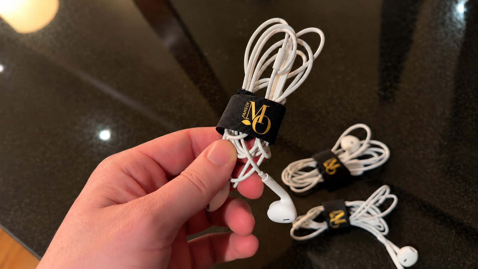 Earphones neatly bundled in black and gold Mandarin Oriental cable wraps