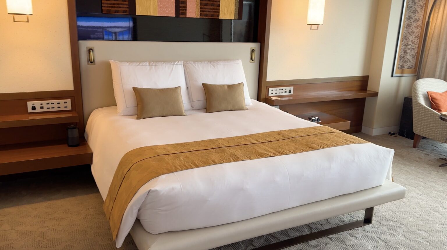 Freshly made bed with white bedding and a gold runner in our Deluxe Premier room