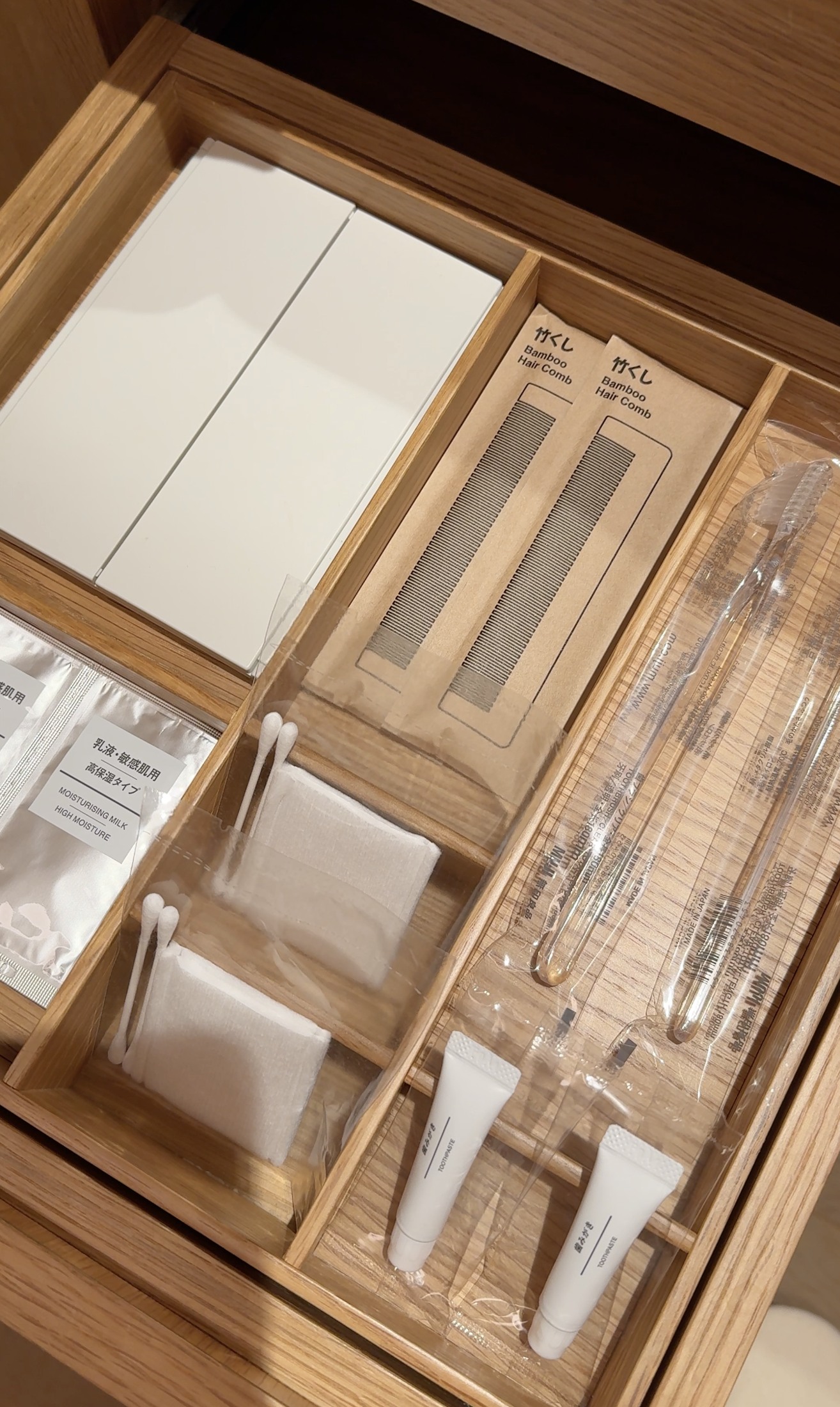 Bamboo combs, toothbrushes, toothpaste, cotton pads and skincare sachets in our MUJI hotel drawer
