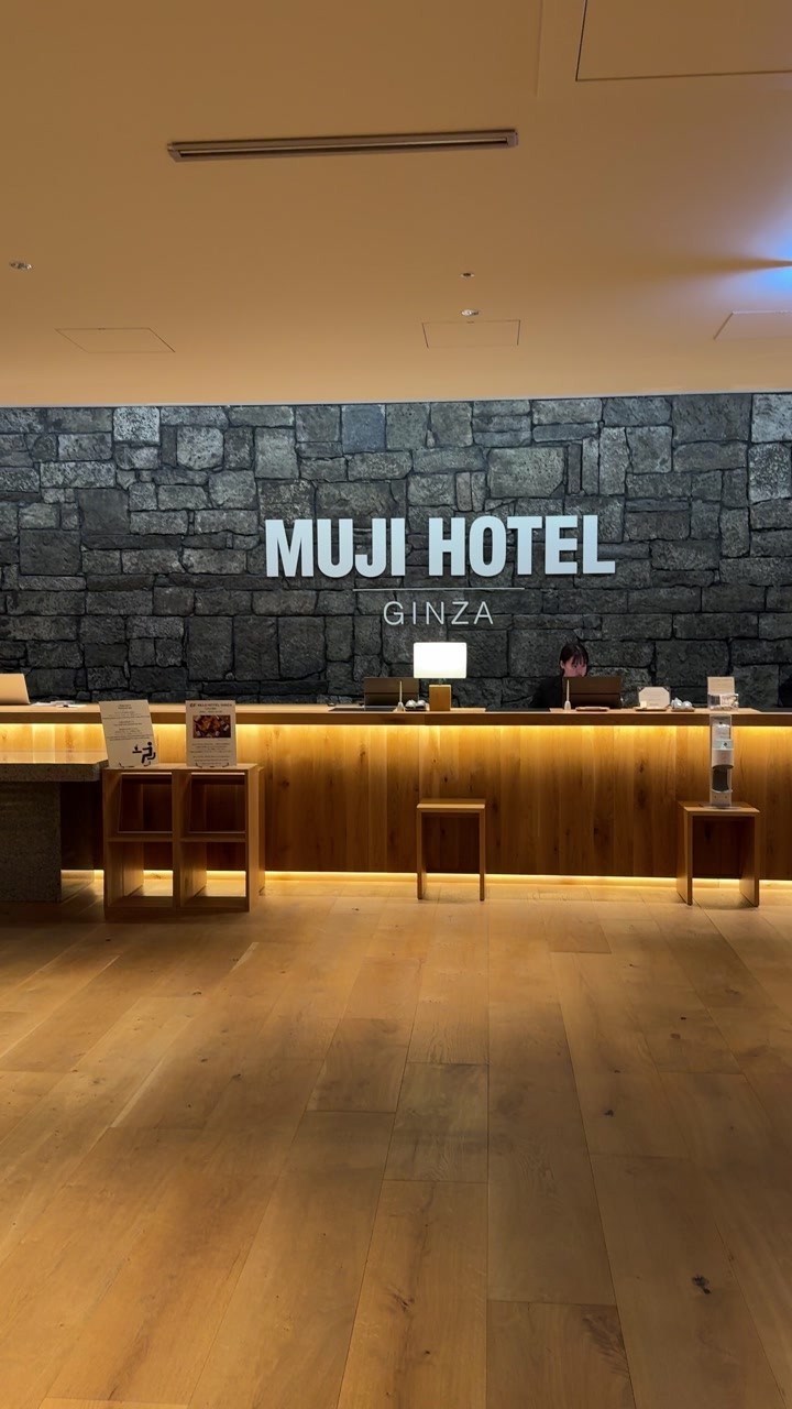 MUJI HOTEL GINZA reception, with a stone backdrop and warm wooden counter