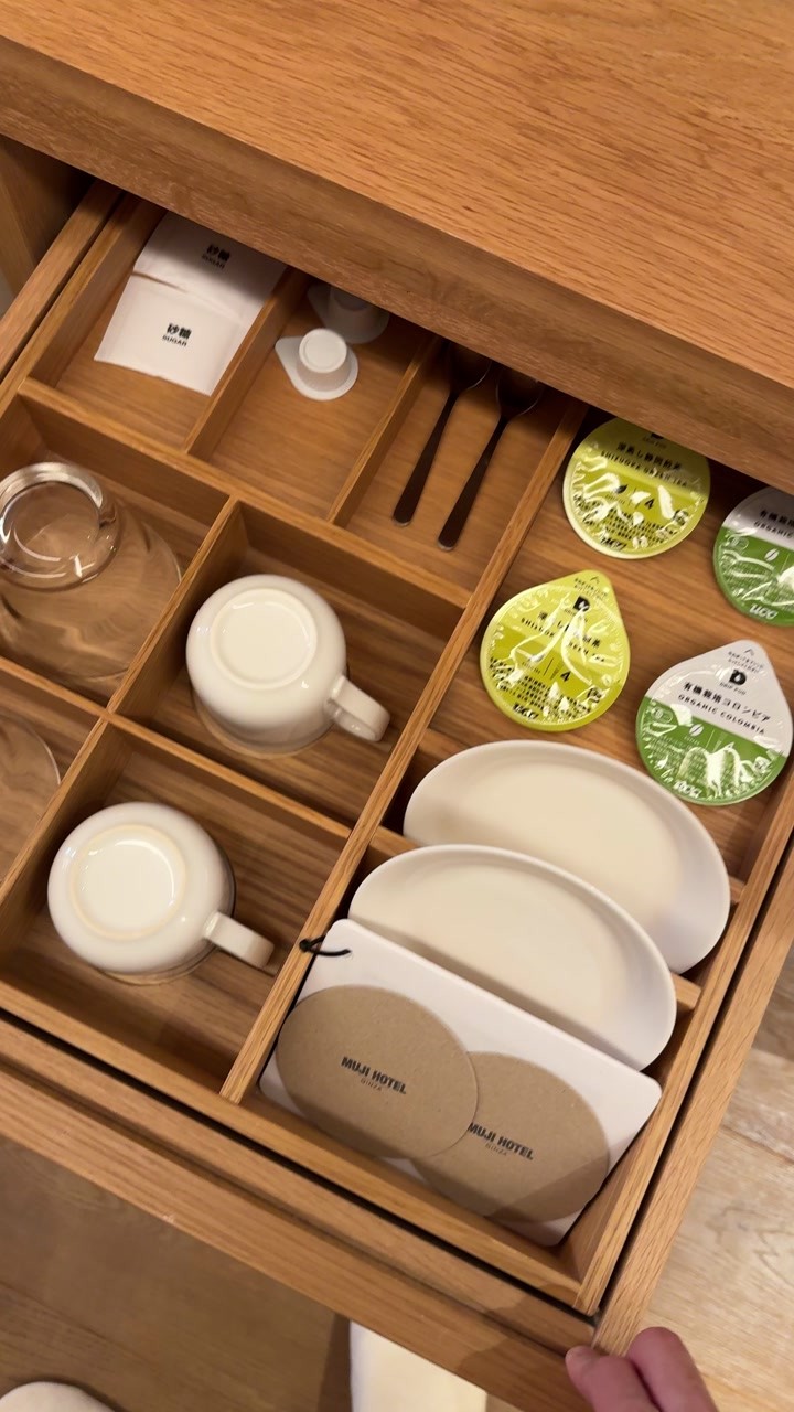 Cups and tea capsules neatly arranged in a wooden drawer at MUJI HOTEL GINZA