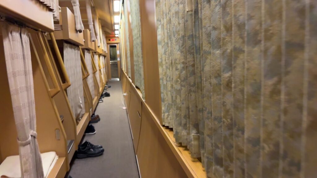 Passage beside the curtained sleeping spaces in the Sunrise Express Nobi Nobi car